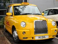 Taxi londinese con targa che pubblicizza DHL
